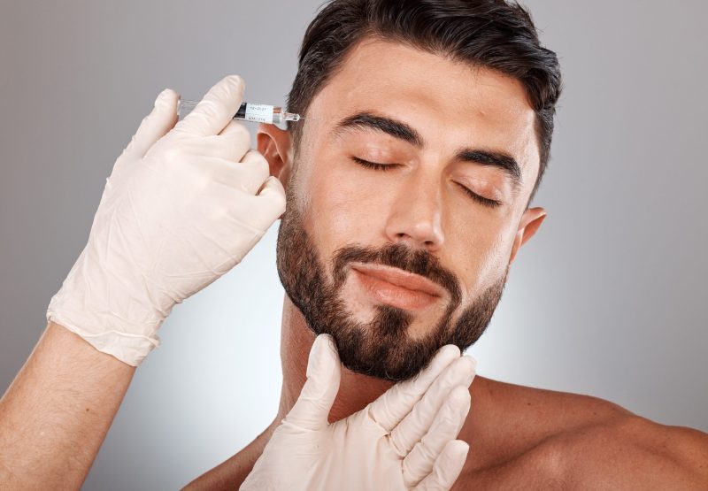 Botox, beauty and injection of man and plastic surgery hands in studio medical aesthetic, face change and dermatology. Mesotherapy, hyaluronic acid or collagen help, trust and doctor cosmetics filler.