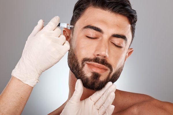 Botox, beauty and injection of man and plastic surgery hands in studio medical aesthetic, face change and dermatology. Mesotherapy, hyaluronic acid or collagen help, trust and doctor cosmetics filler.